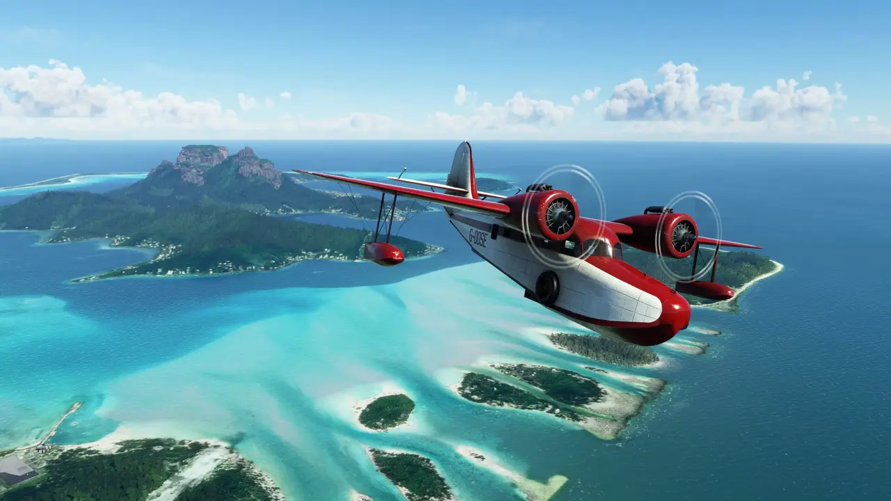 The Grumman G-21 Goose in the 40th Anniversary Edition, red and white, flying over a turquoise lagoon and islands