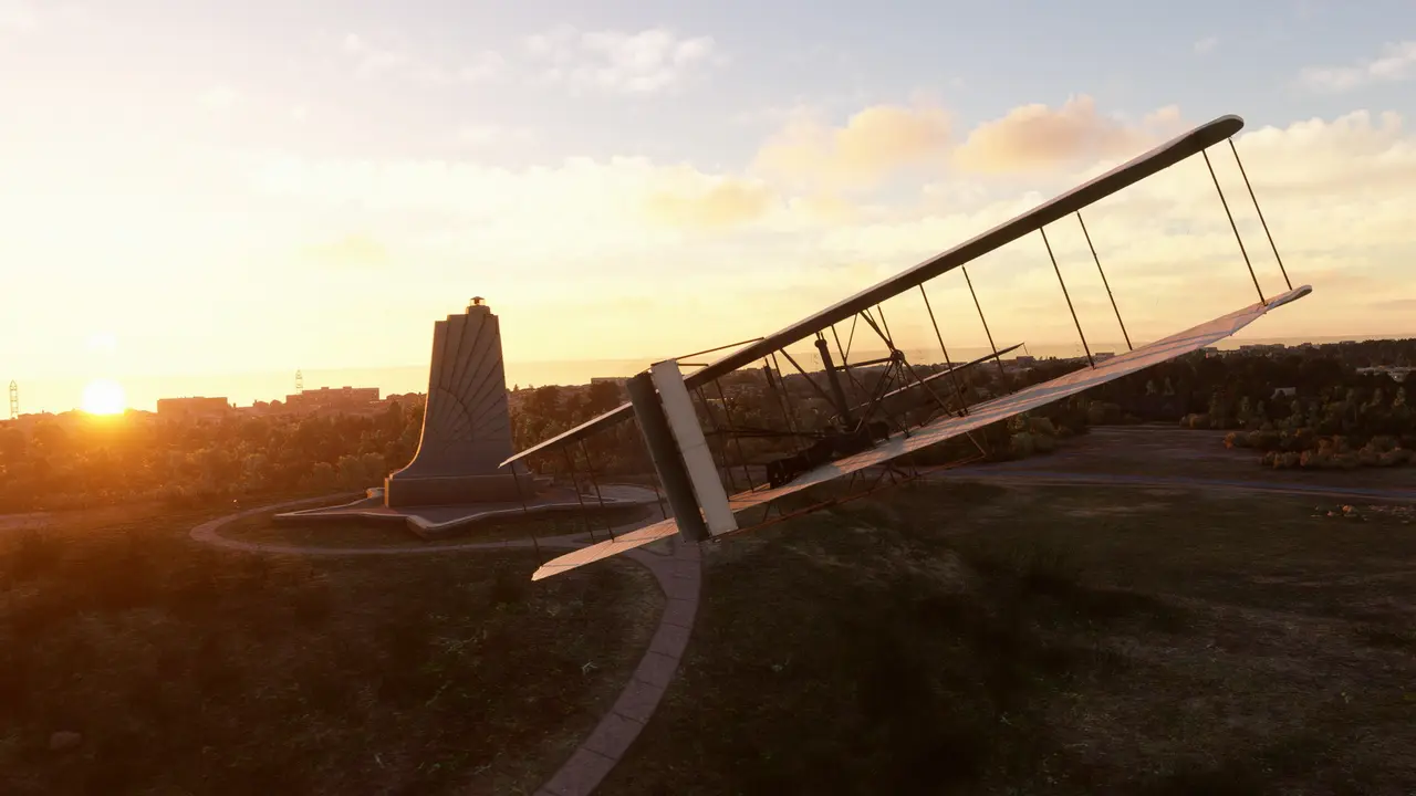 The 1903 Wright Flyer in flight at sunset beside the Wright Brothers National Memorial at Kitty Hawk