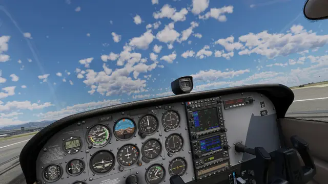 The cockpit of a Cessna 172 on the runway in X-Plane 12, with round gauges and a sky full of small clouds
